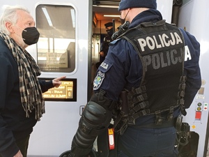 zdjęcie kolorowe: policjant katowickiego oddziału prewencji rozmawiający z mężczyzną
