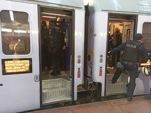 zdjęcie kolorowe: policjanci katowickiego oddziału prewencji wsiadający do pociągu z uchodźcami