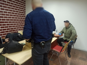zdjęcie kolorowe: dwóch nieumundurowanych policjantów stojących prze stole na komisariacie w katowickim spodku