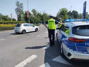 zdjęcie kolorowe: policjanci wydziału drogowego zabezpieczający trasę przejazdu kibiców