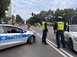 zdjęcie kolorowe: policjanci katowickiej drogówki na skrzyżowaniu zabezpieczają uczestników maratonu