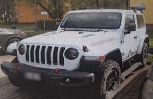 zdjęcie kolorowe: odzyskany biały jeep, zaparkowany na osiedlowym parkingu