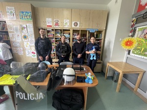 zdjęcie kolorowe przedstawiające umundurowanych policjantów wraz ze Sznupkiem w sali w Górnośląskim Centrum Zdrowia Dziecka