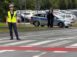 zdjęcie kolorowe: policjanci ruchu drogowego zabezpieczający przejazd kibiców na mecz piłki nożnej