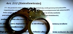 na zdjęciu policyjne kajdanki oraz kartka z napisem artykuł 212 zniesławienie