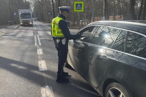 Na zdjęciu policjant badający trzeźwość kierowcy