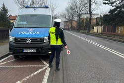 Na zdjęciu radiowóz u umundurowana policjantka