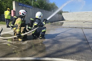 Na zdjęciu strażacy podający strumień wody
