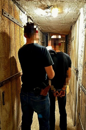 Na zdjęciu zatrzymany wraz z nieumundurowanymi policjantami
