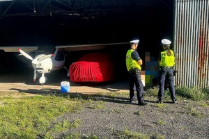 Na zdjęciu policjanci przy hangarze