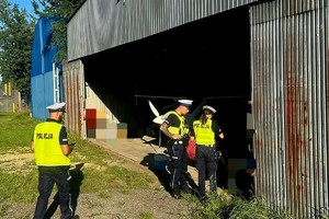 Na zdjęciu policjanci przy hangarze