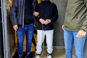 NA zdjęciu zatrzymany z policjantami