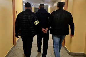 Na zdjęciu policjanci z zatrzymanym