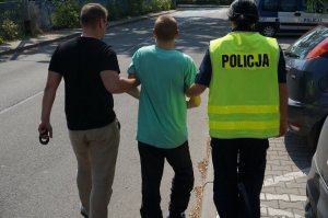 Policjanci prowadzący osobę zatrzymaną