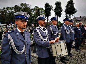 na pierwszym planie widać policjantów orkiestry grających na instrumentach, obok nich mundurowi z kierownictwa śląskich jednostek Policji