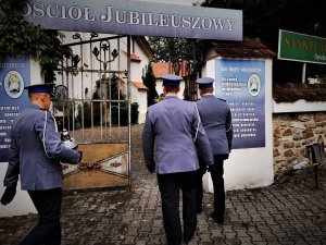 trzech umundorowanych policjantów wchodzi na teren sanktuarium w Mikołowie