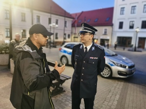 policjant w mundurze galowym rozmawia z mężczyzną
