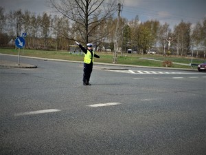 stojąca na środku skrzyżowania policjantka ruchu drogowego, która kieruje ruchem
