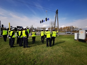 stojący w grupie policjanci ruchu drogowego, na zdjęciu widać dron, który filmuje ich działania