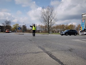 policjant drogówki kieruje ruchem na skrzyżowaniu w Mikołowie. Obok niego przejeżdżają auta