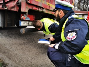 policjanci kucają przy ciężarówce