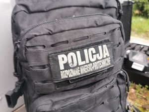 na zdjęciu widoczny plecak policjanta z napisem POLICJA minersko-pirotechniczna