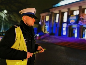 zdjęcie przedstawia policjanta ruchu drogowego, w tle budynek domu kultury