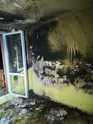 na zdjęciu widać wnętrze zadymionej od ognia kuchni. Jest otwarte okno balkonowe