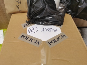 na zdjęciu kartonowe pudło oklejone taśmą z napisem POLICJA