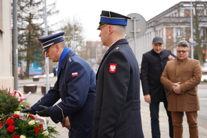 komendant Policji składa wiązankę kwiatów pod pomnikiem
