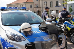 policyjny radiowóz, a na jego masce rozłożony policyjny sprzęt