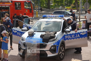 na zdjęciu widać oznakowany radiowóz marki Kia, a na nim rozłożony policyjny sprzęt