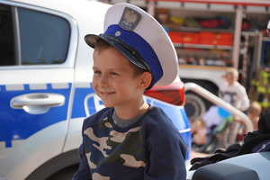 mały chłopiec pozuje do zdjęcia w czapce policjanta drogówki. Dziecko siedzi na motocyklu