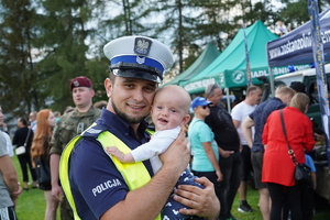 policjant drogówki trzyma na rękach malutką dziewczynkę