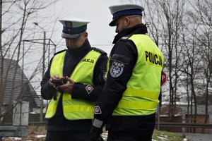 dwaj policjanci drogówki podczas kontroli samochodu osobowego