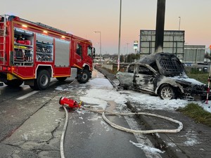 na zdjeciu widać zniszczony samochód i wóz strażacki