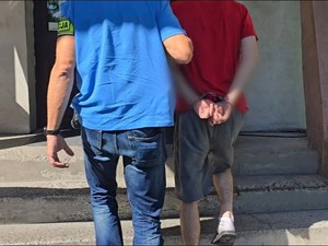 na zdjeciu widać mężczyznę w kajdankach i policjanta kryminalnego