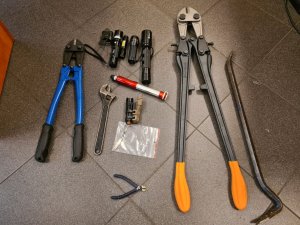 zdjęcie narzędzi (łom, nożyce do cięcia metalu) i latarek wykorzystywanych przez złodzieja do kradzieży