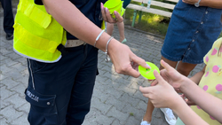 zdjęcie przedstawia zbliżenie na odblaski trzymane w rękach policjanta