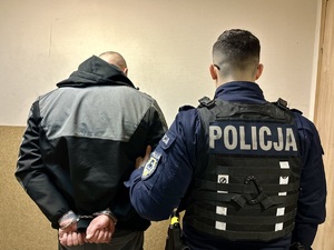 zdjęcie przedstawia zatrzymanego stojącego razem z policjantem