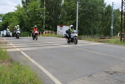 zdjęcie przedstawia policjanta na motocyklu zabezpieczającego przejazd motocyklistów