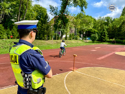 zdjęcie przedstawia policjantów w trakcie przeprowadzania egzaminu na kartę rowerową dla dzieci.