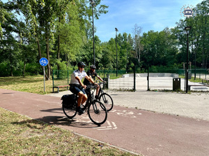 zdjęcie przedstawia policjanta i strażnika miejskiego na rowerach.