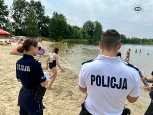 zdjęcie przedstawia policjantów w trakcie rozmowy z plażowiczami