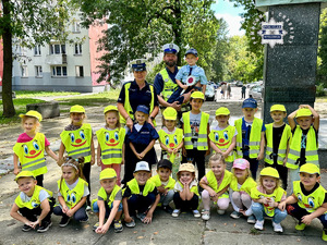 zdjęcie grupowe na którym widoczne są dzieci i policjanci w odblaskowych kamizelkach.