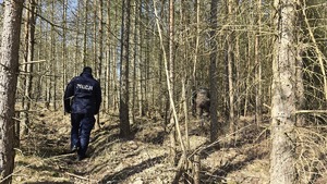 zdjęcie przedstawia policjantów i strażnika leśnego w lesie