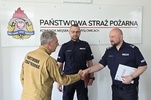 zdjęcie przedstawia komendantów składających podziękowania policjantowi