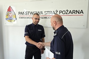 zdjęcie przedstawia komendantów składających podziękowania policjantowi