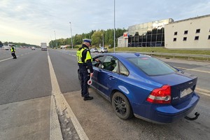 zdjęcie przedstawia policjantów w trakcie kontroli trzeźwości na autostradzie