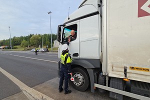 zdjęcie przedstawia policjantów w trakcie kontroli trzeźwości na autostradzie